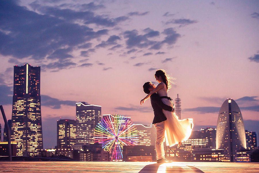 みなとみらいの綺麗な夕焼けを背景に新婦を持ち上げる新郎