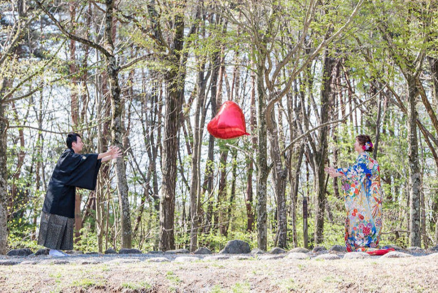 ハートの風船を投げる新郎