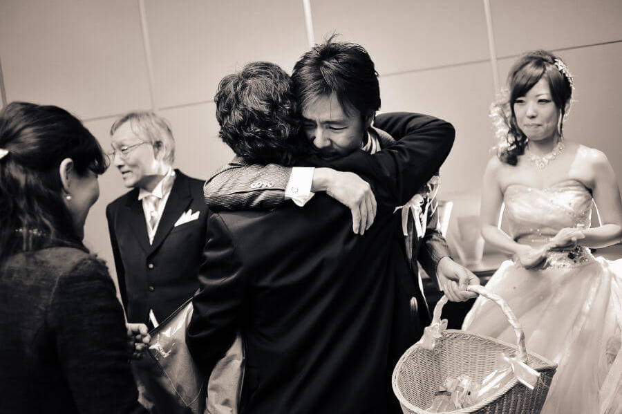 友人と抱き合う新郎